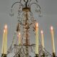 Golden bronze chandelier trimmed with drop-shaped grapevines