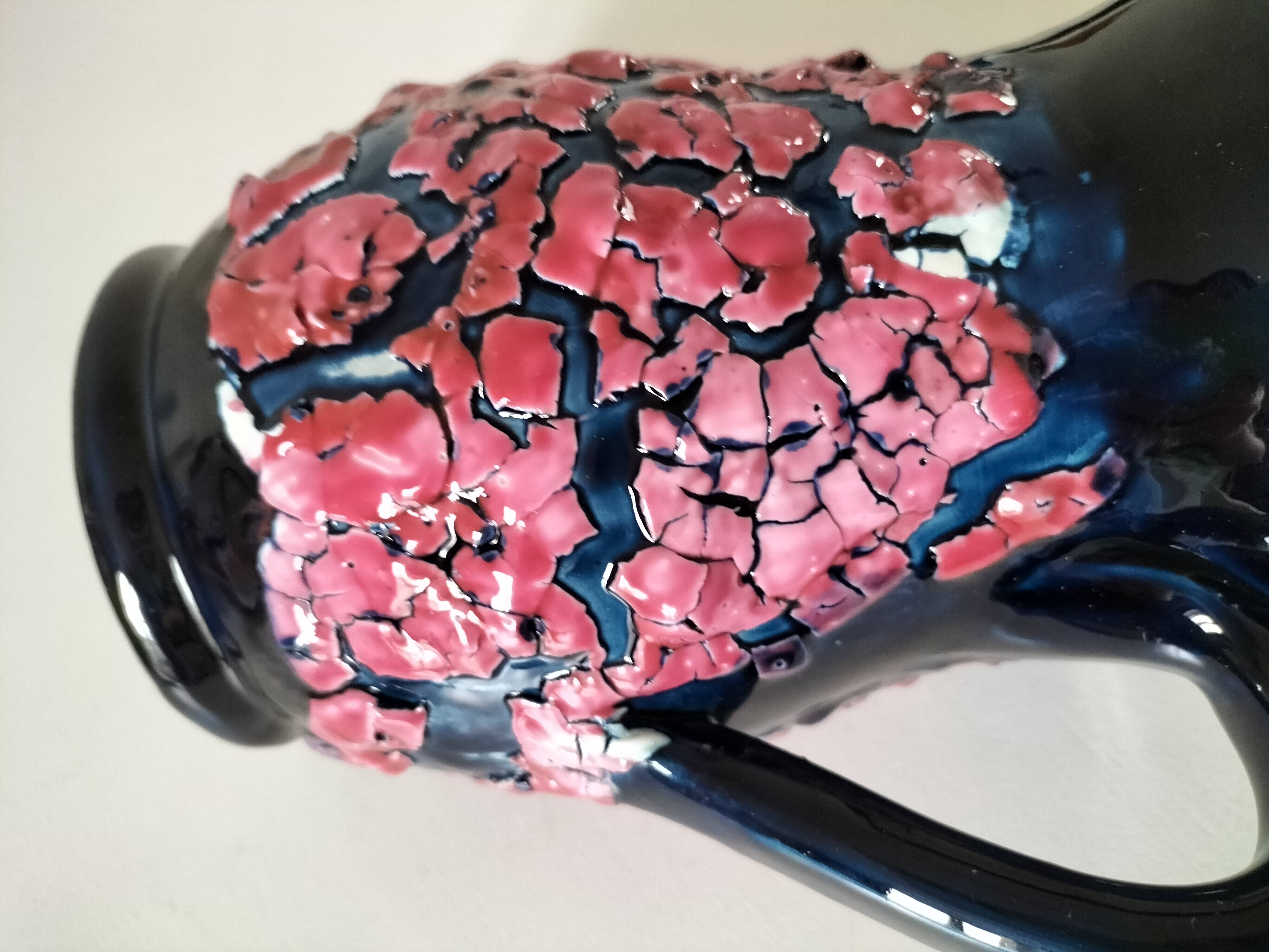 Vintage pitcher in midnight blue glazed ceramic with bright pink relief
