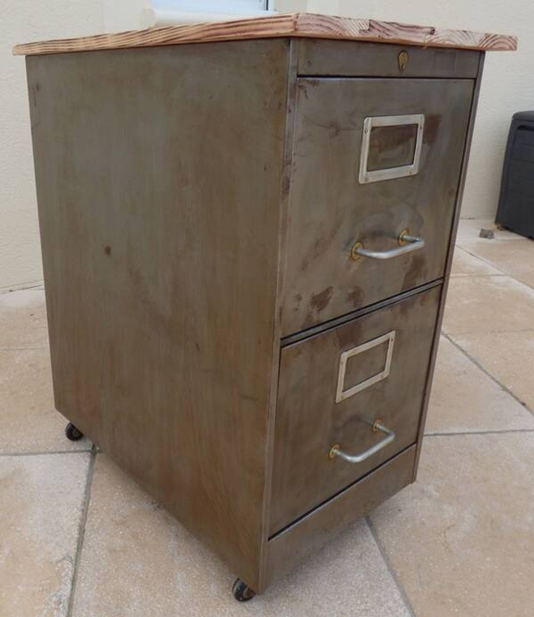 Vintage industrial metal furniture with a rusty effect, featuring two drawers on wheels.