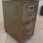 Vintage industrial metal furniture with a rusty effect, featuring two drawers on wheels.