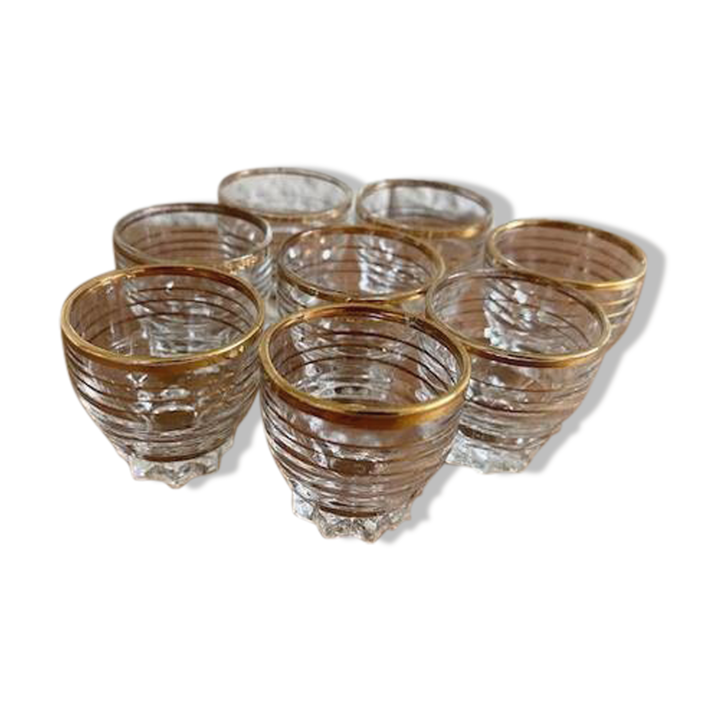 Suite of eight liqueur glasses in white glass and gold highlights. Circa 1970