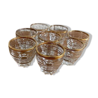 Suite of eight liqueur glasses in white glass and gold highlights. Circa 1970