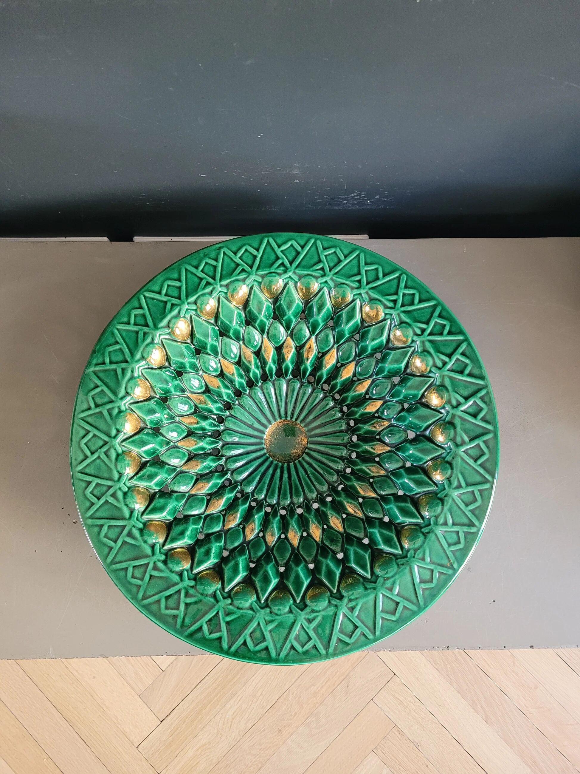 Large pierced earthenware fruit bowl glazed in green and gold.