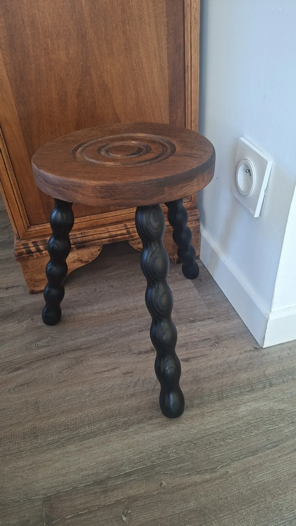Brown and black wooden tripod stool