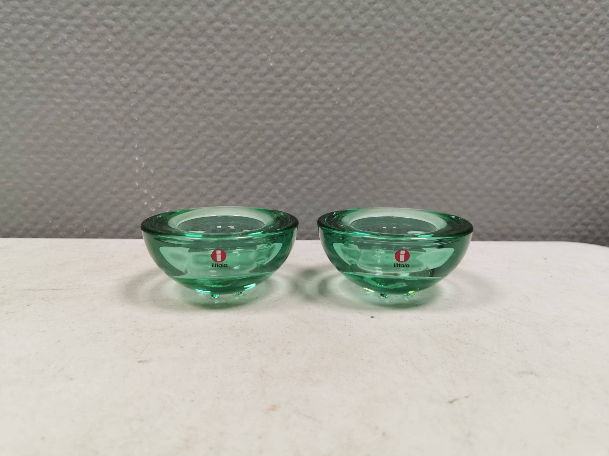 A set of iitalla candle holders in green transparent glass.