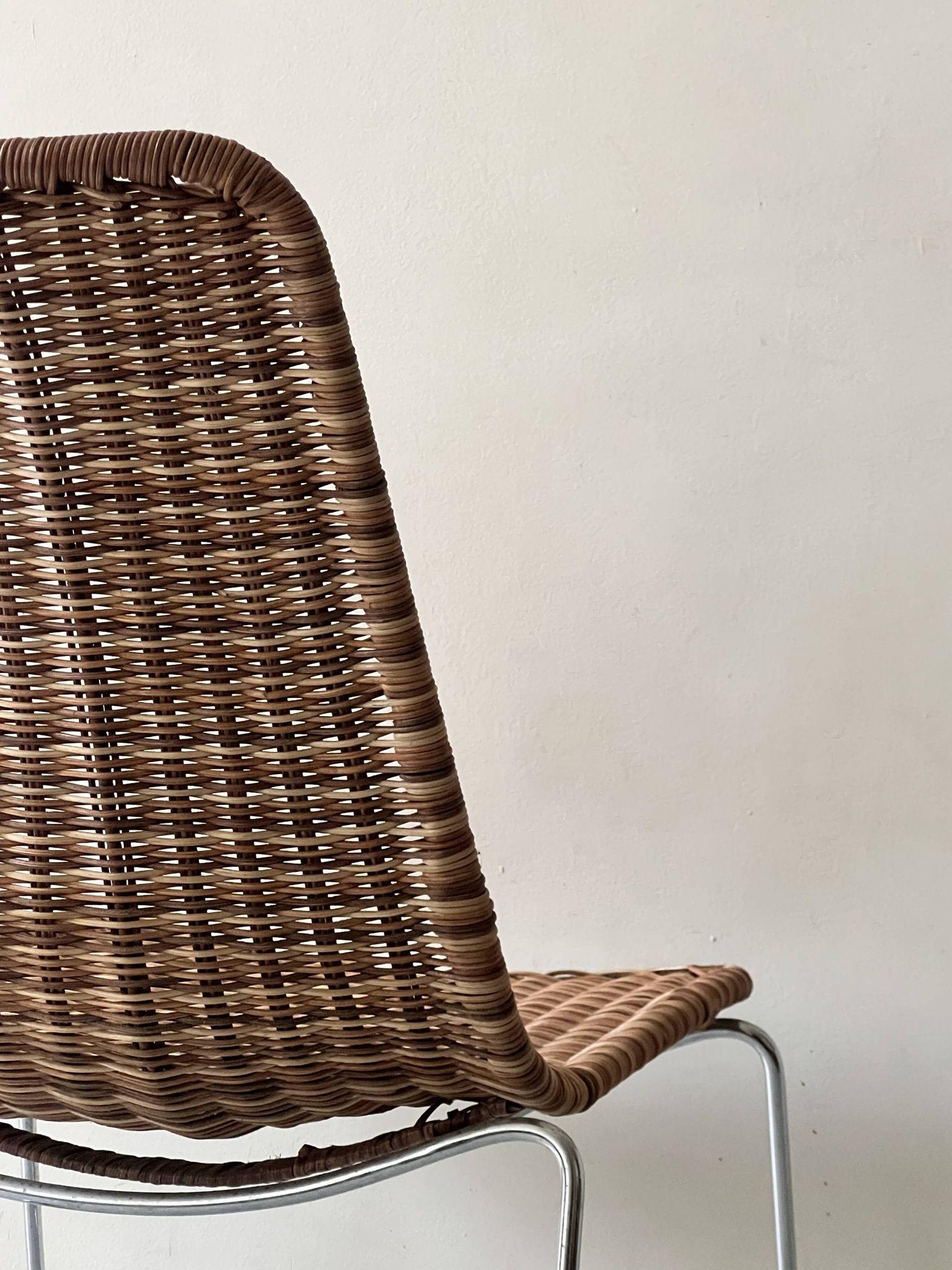 Chair design in rattan, woven wicker and chrome wire metal.