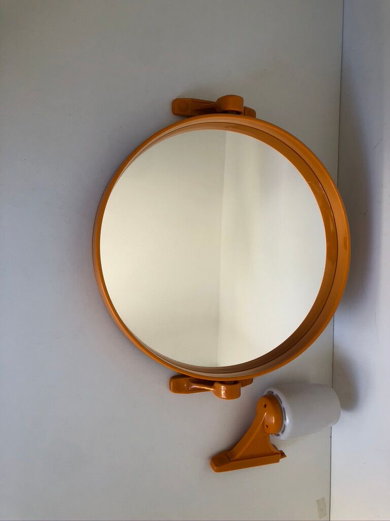 Tiltable orange plastic mirror with matching wall light