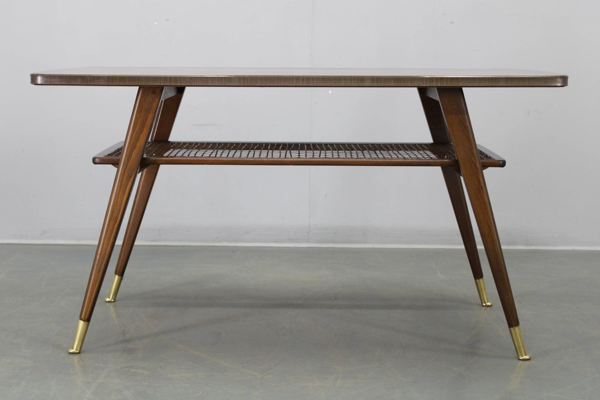 Mid-century German coffee table with rattan shelf and brass legs