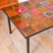 Ceramic and black iron coffee table, attributed to the Roche-Bobois brand, with a black metal base and structure, rectangular ceramic top from Vallauris with colourful patterns in ochre and orange, design from the 1970s.