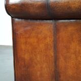 Canapé en cuir de mouton 2,5 places, luxueux et confortable, avec des coussins en tissu.