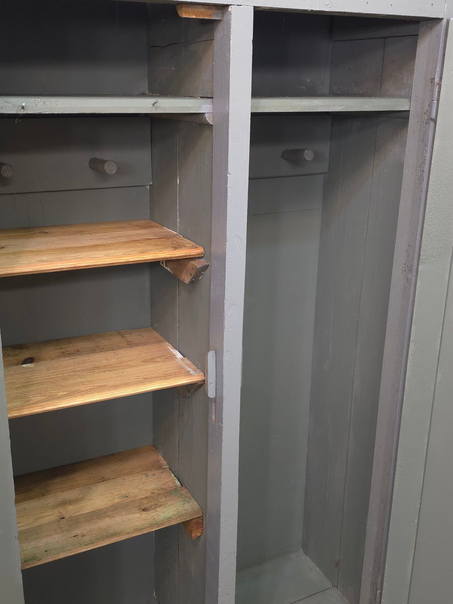 Curved wardrobe workshop locker made of wood repainted in grey.
