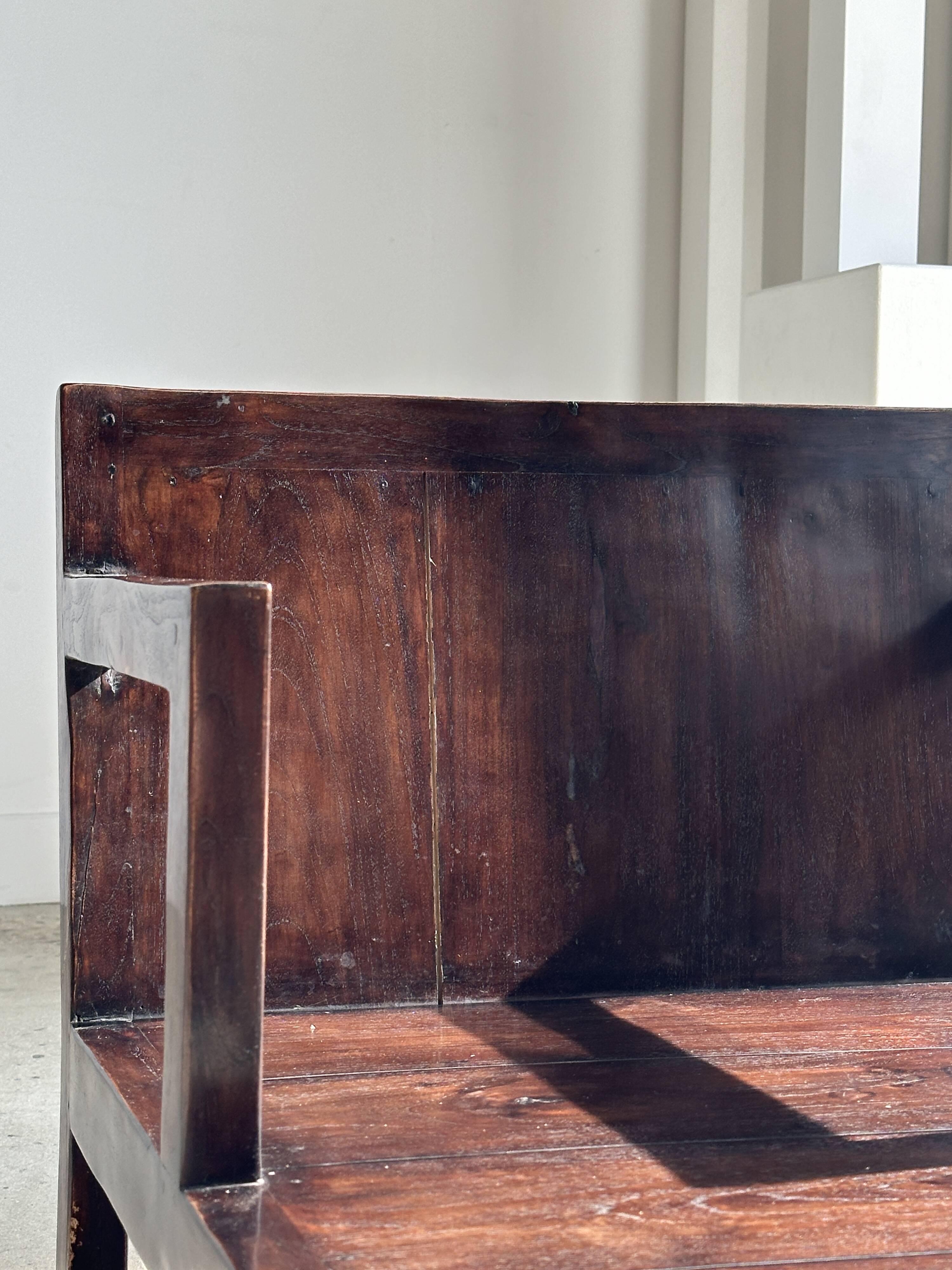 Small low armchair in varnished brown wood
