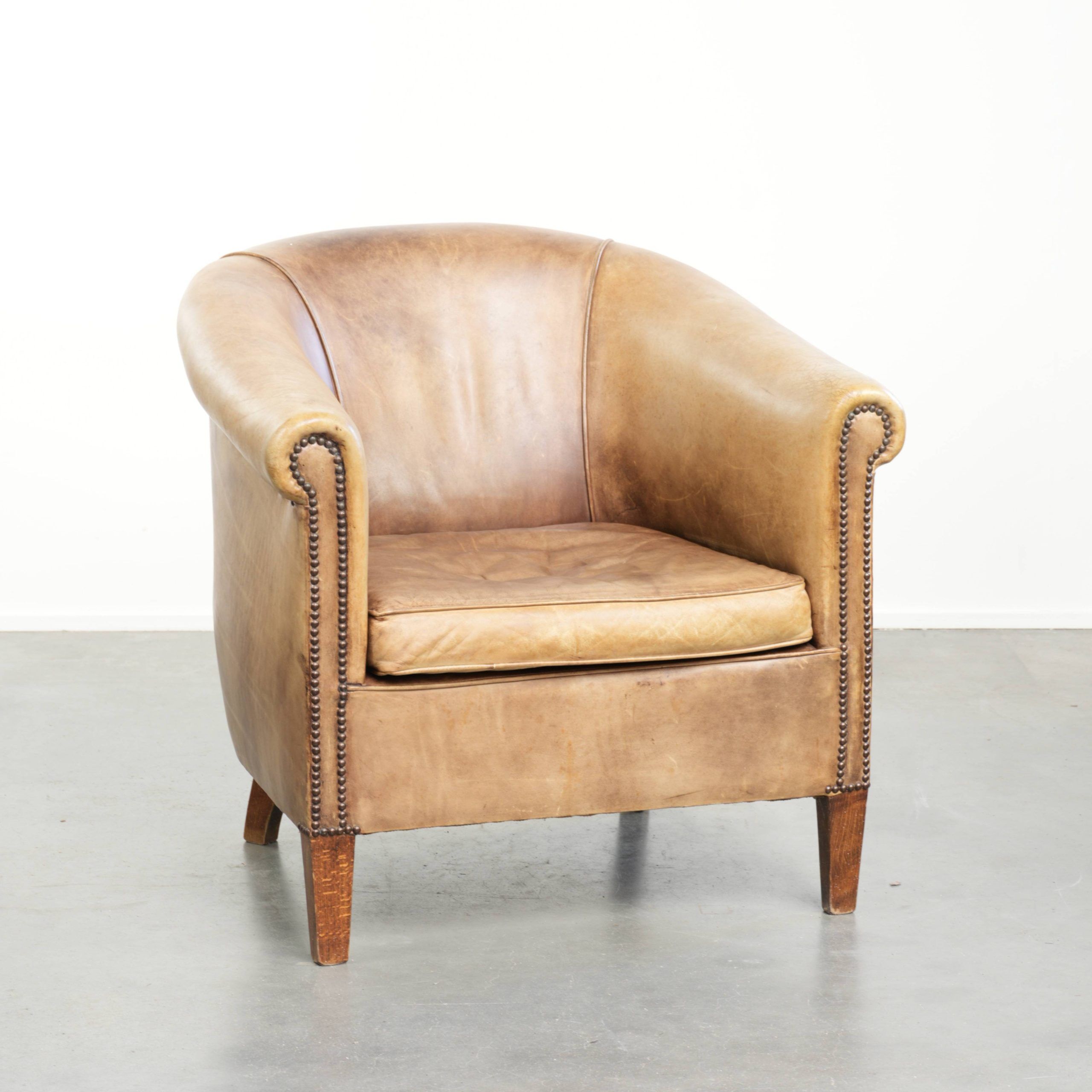 Vintage cowhide club armchair in English style in a light colour scheme