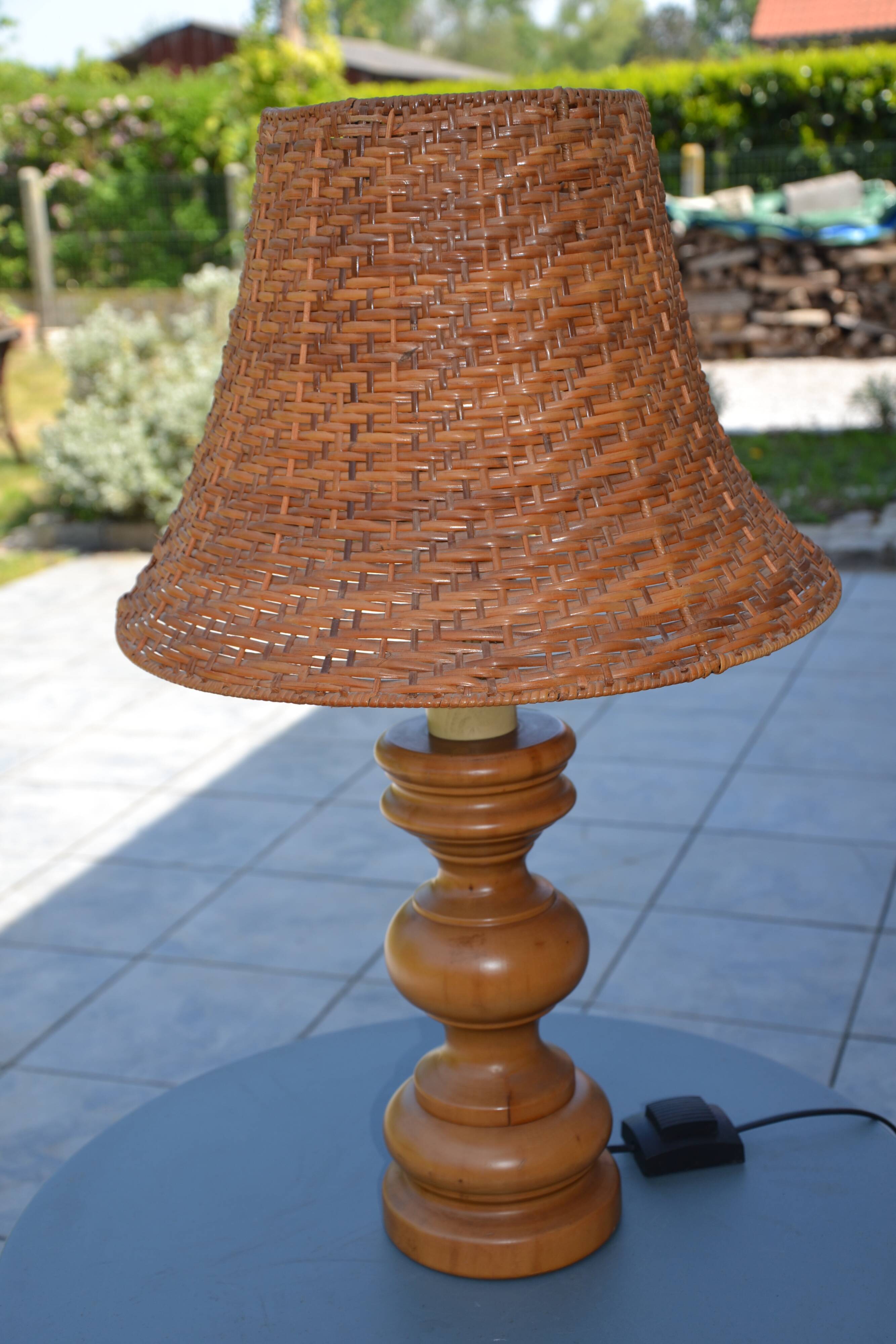 Large wooden lamp with a woven rattan shade.