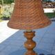 Large wooden lamp with a woven rattan shade.