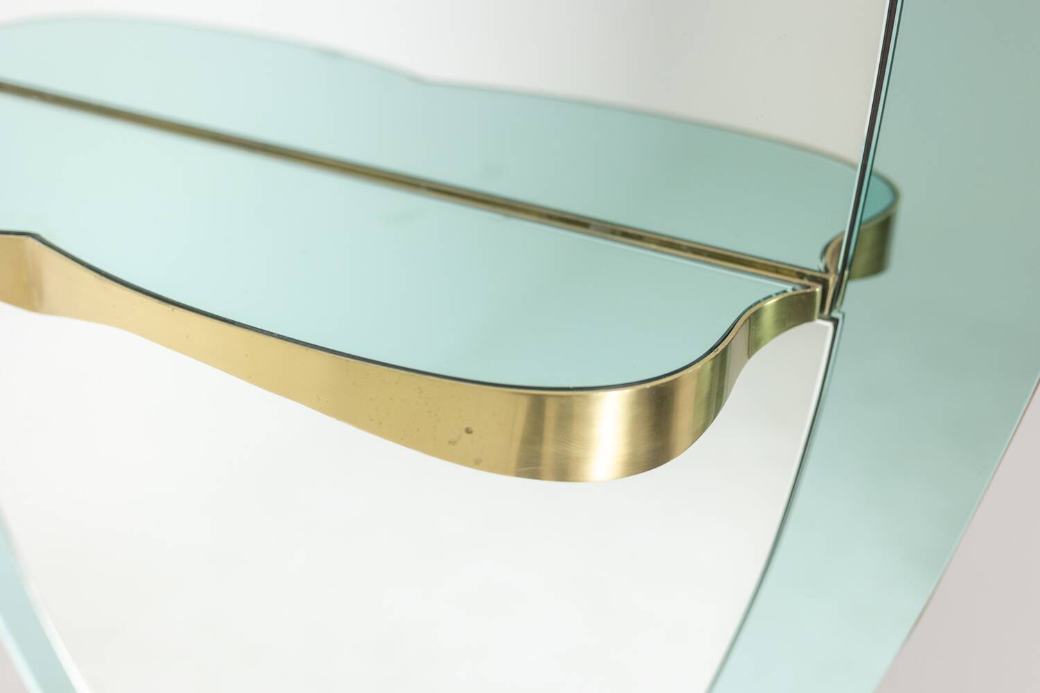 Two-tone glass console mirror with gilded brass. Circa 1950.