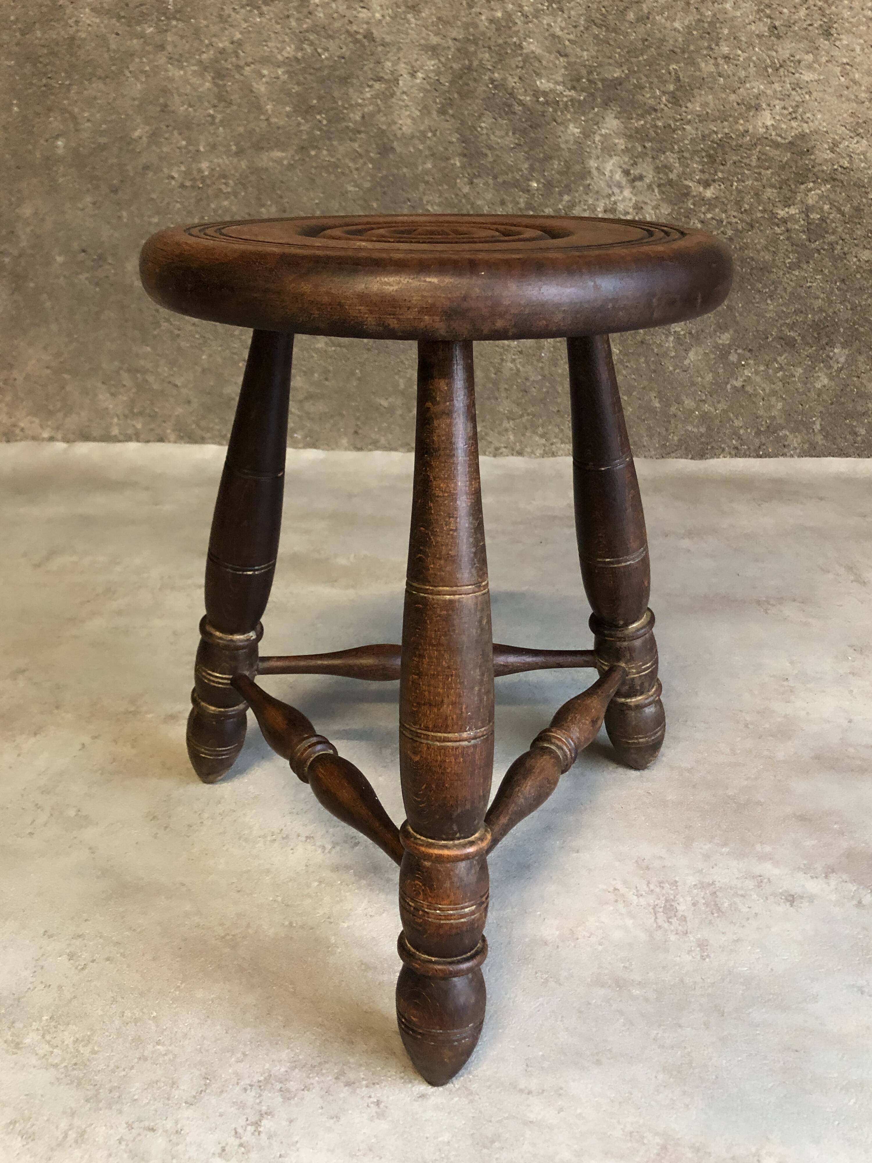 Round tripod stool in dark wood