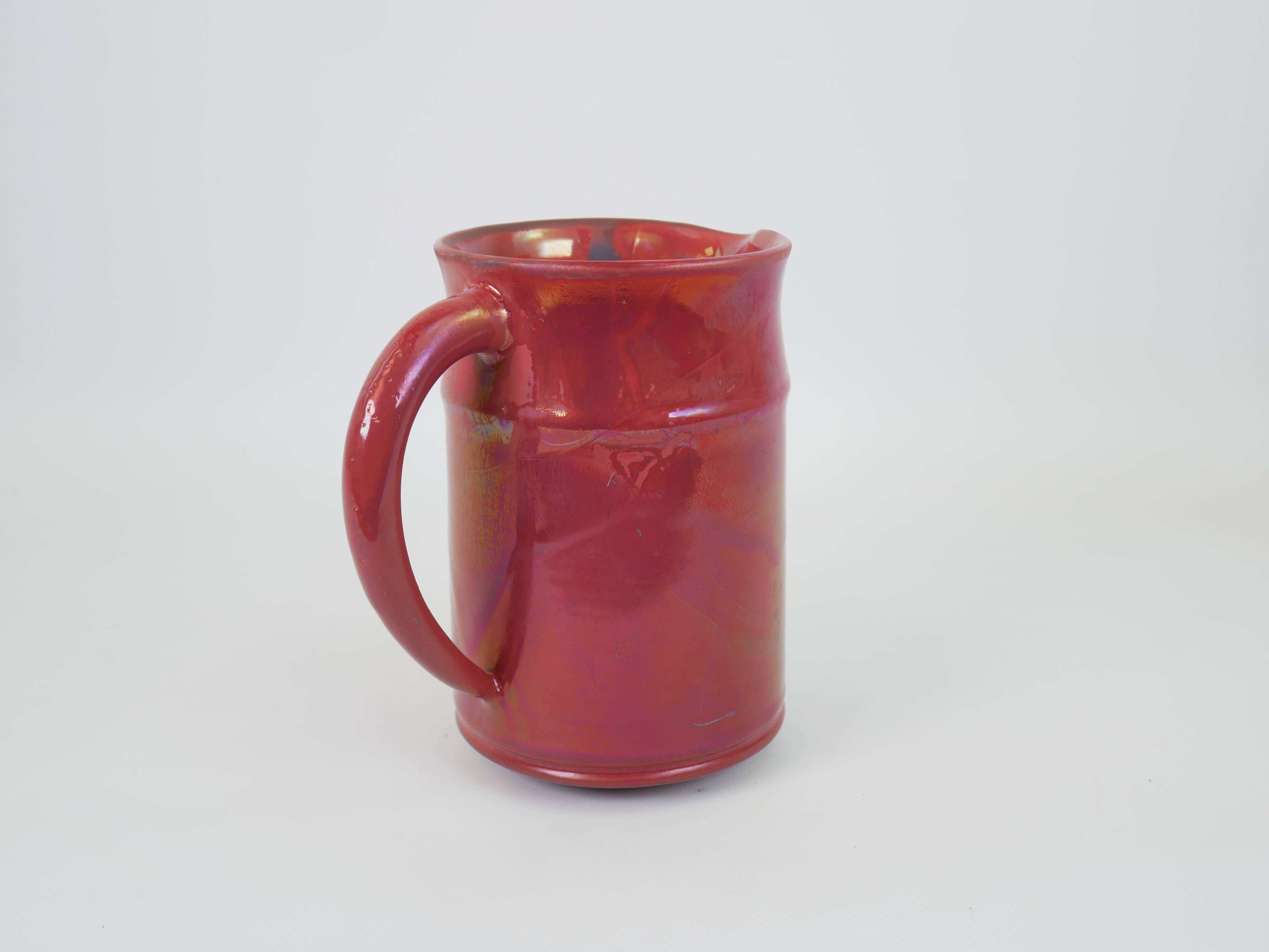 Red glazed ceramic jug with relief