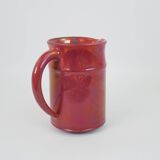 Red glazed ceramic jug with relief