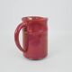 Red glazed ceramic jug with relief