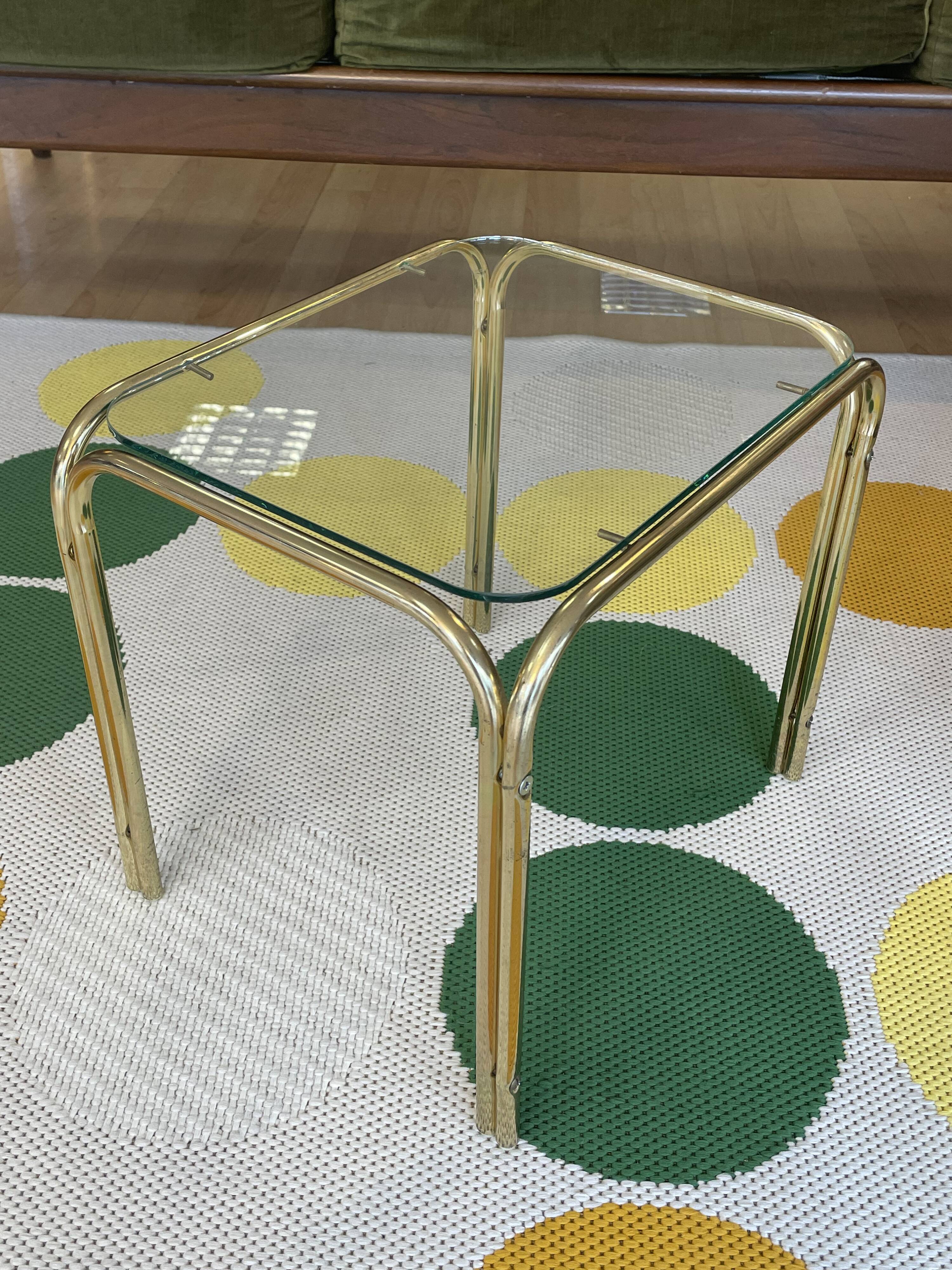 Pair of small nesting coffee tables in gold tubular metal & transparent glass tops