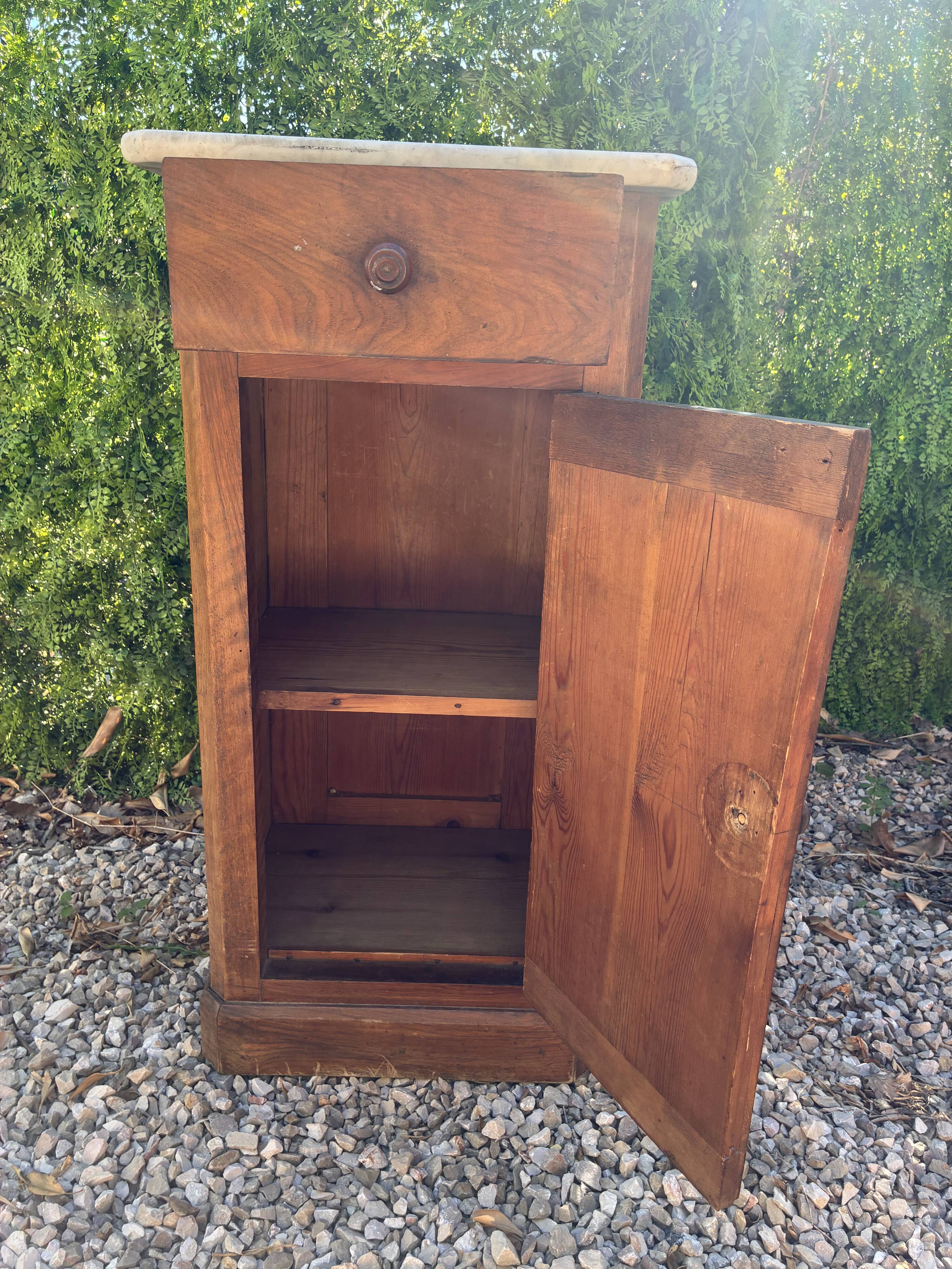 Antique wooden bedside table with marble