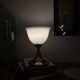 Antique white opaline glass globe table lamp with a brass base.