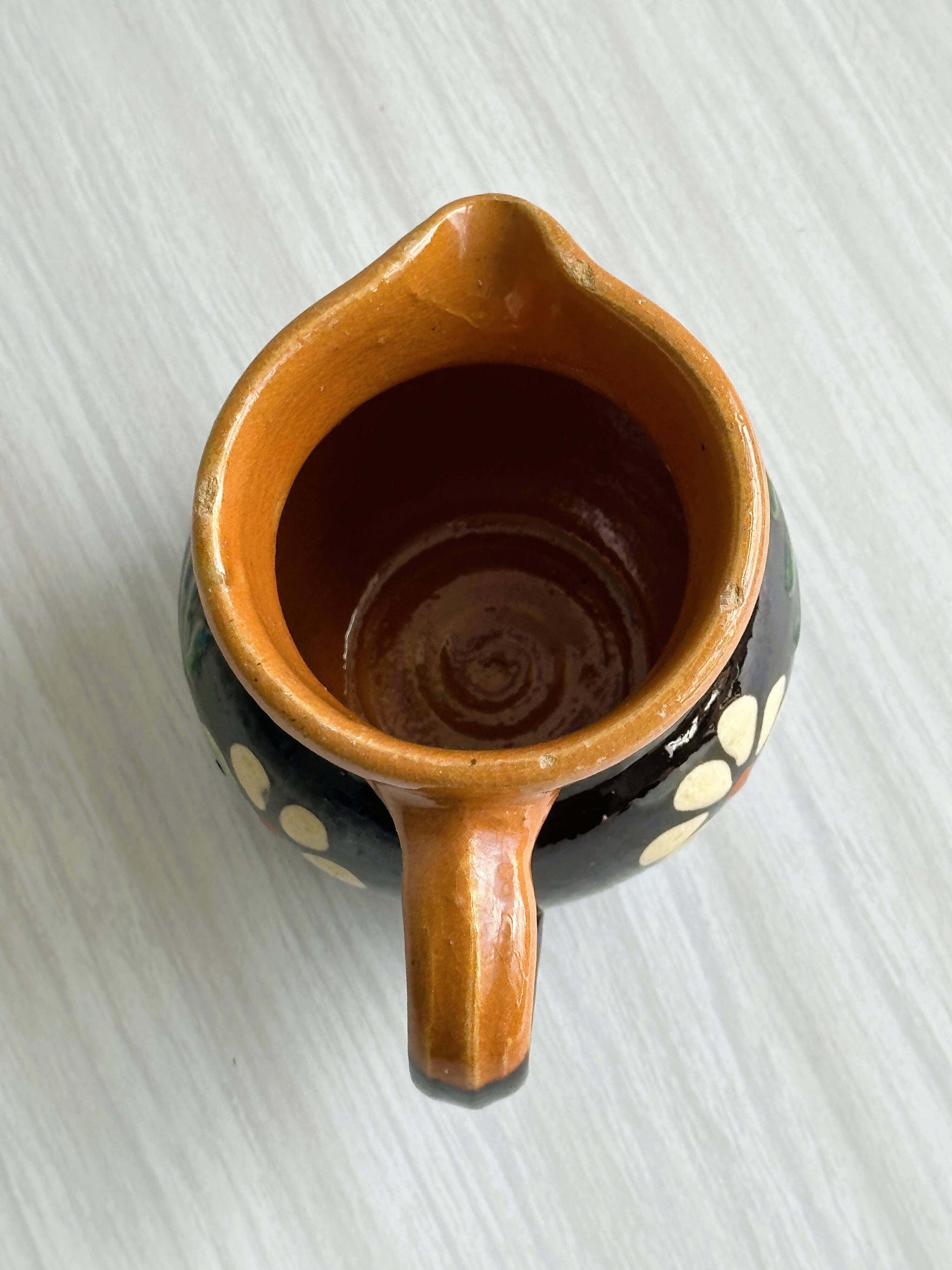 Petit pichet Alsacien en céramique noire et marron, décoré de motifs floraux peints à la main.