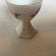 Five old egg cups with orange and grey flowers, polygonal base.