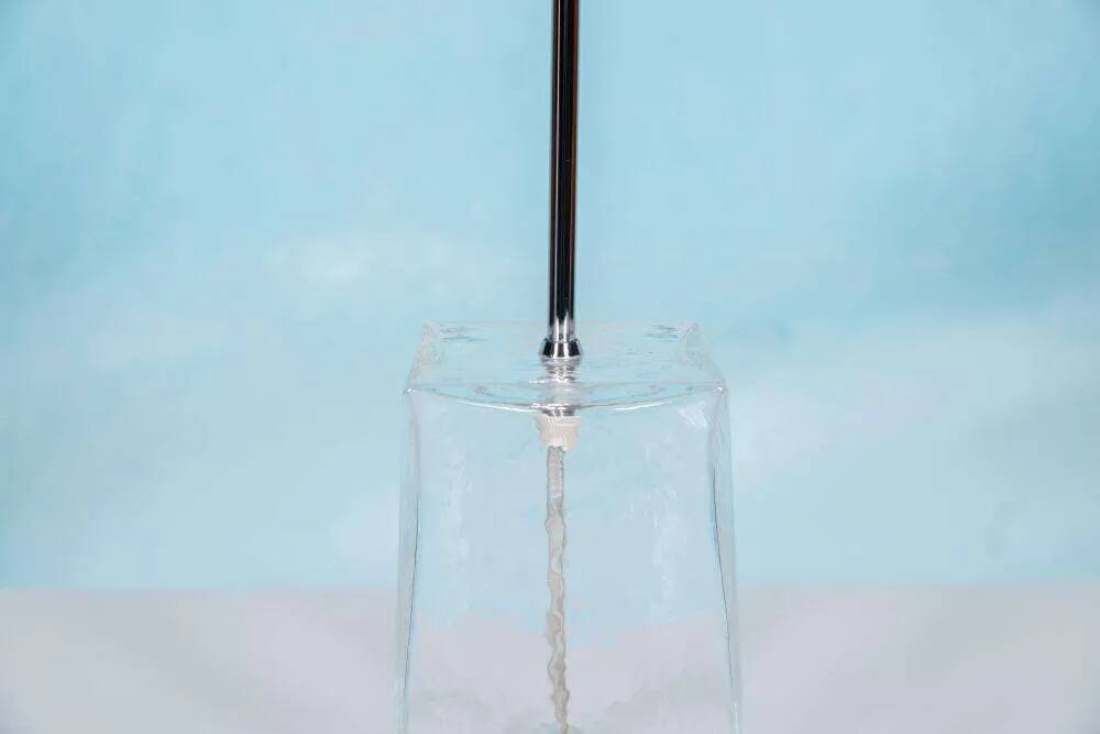 Minimalist glass table lamp from the 80s with a pleated shade.
