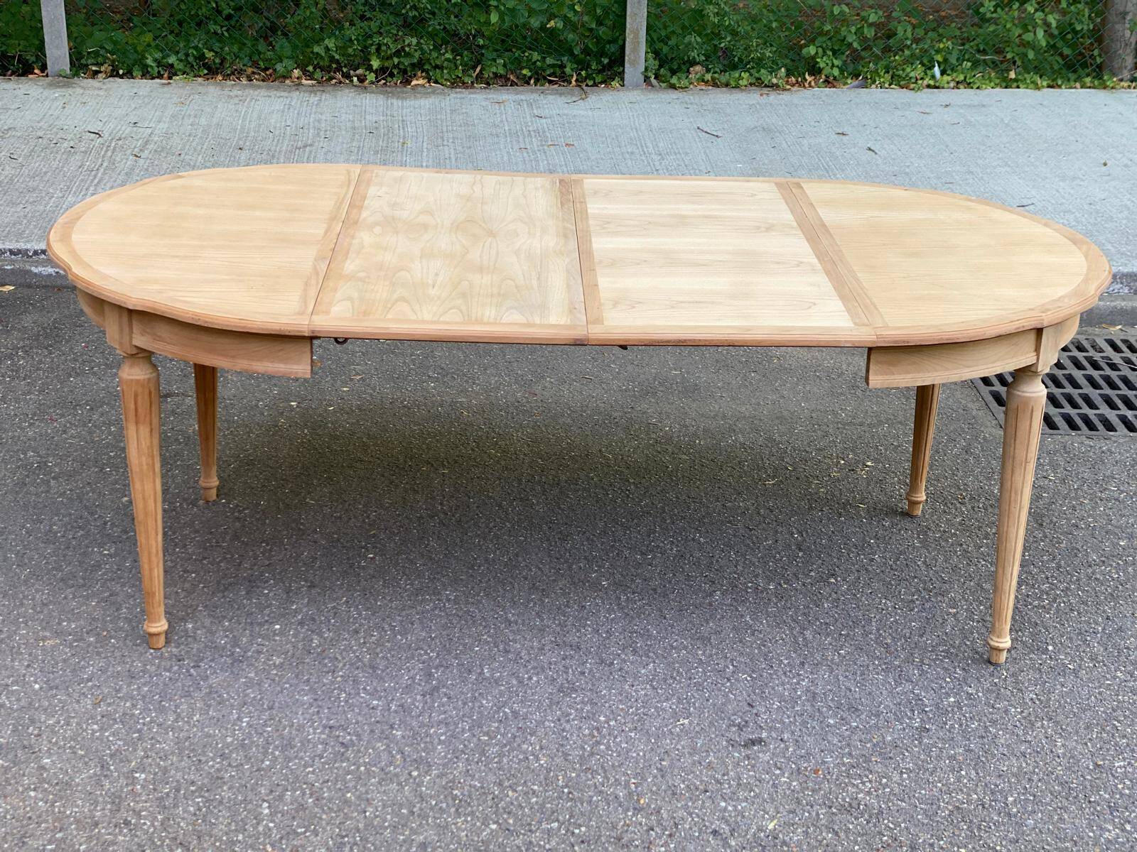 Extendable round table in renovated Louis XVI style, made of light wood, with 2 extensions.
