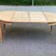 Extendable round table in renovated Louis XVI style, made of light wood, with 2 extensions.