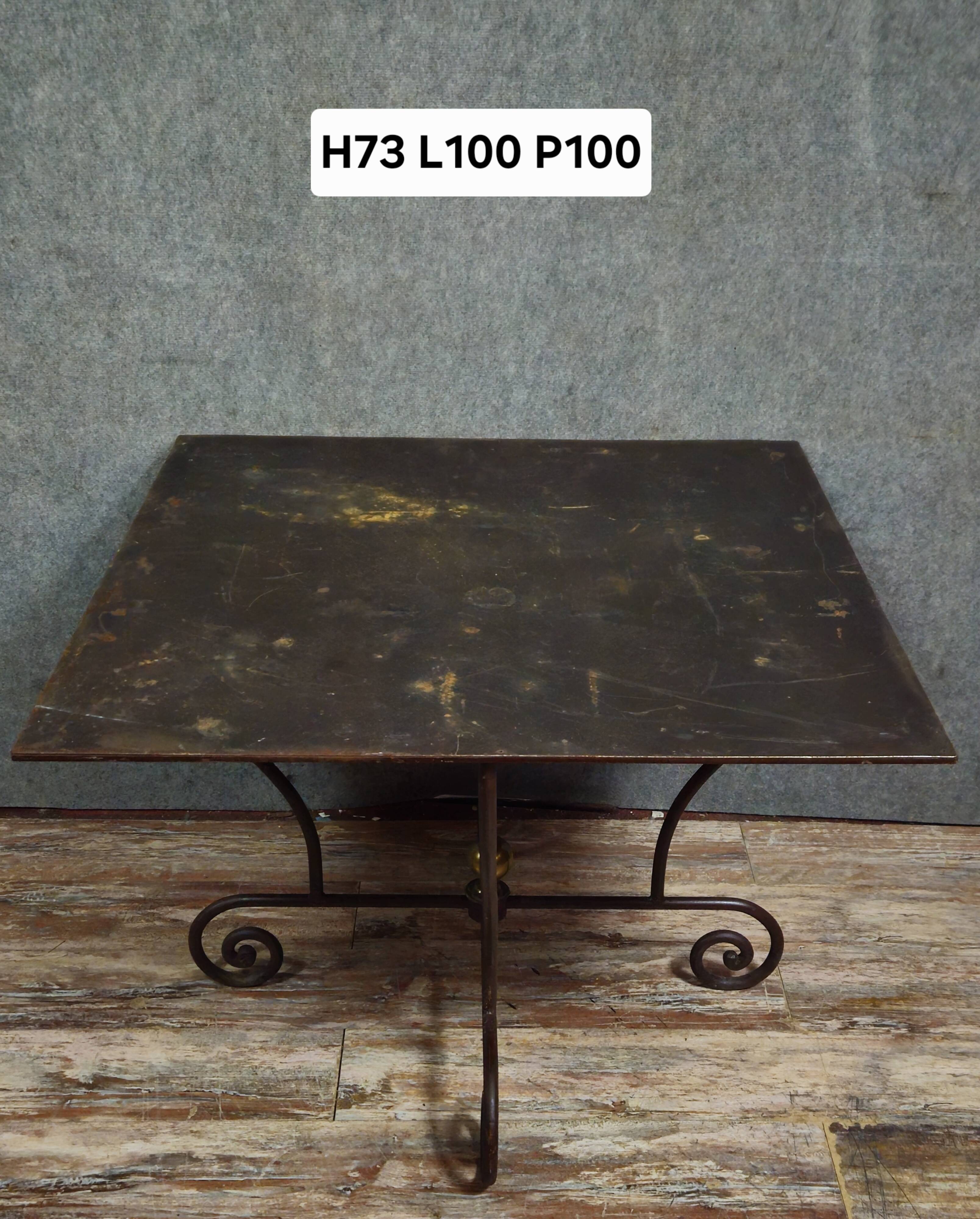 Table en fer forgé à piétement sculptural, ornée de volutes