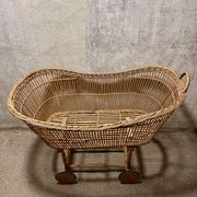Vintage wicker cradle on wheels