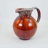 Large red and blue glazed ceramic pitcher signed Delène under the base