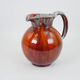 Large red and blue glazed ceramic pitcher signed Delène under the base