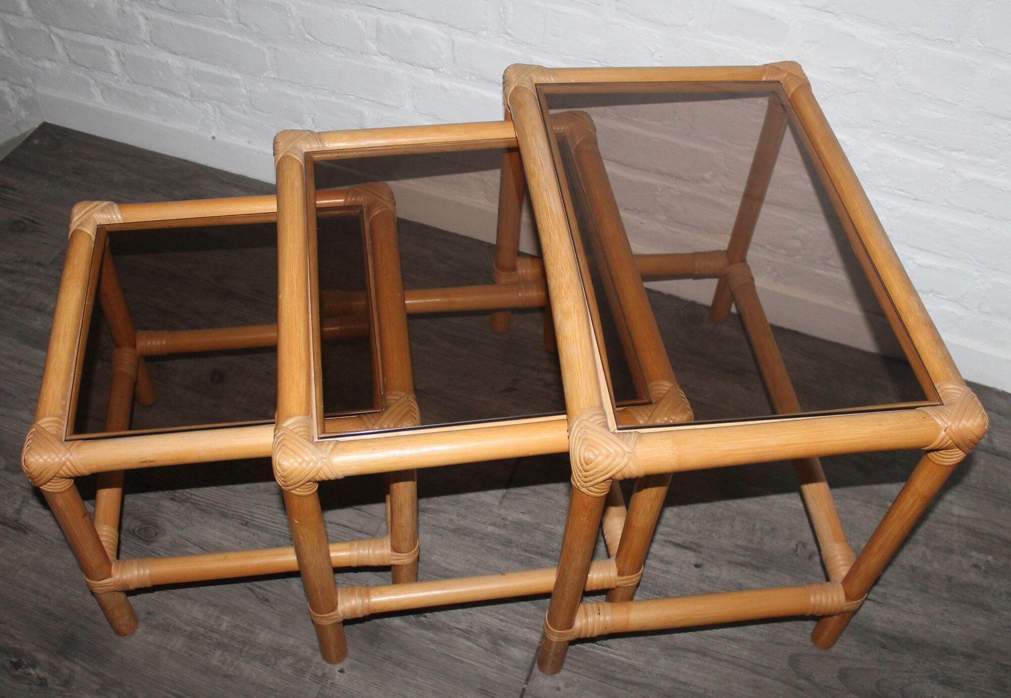 Rattan nesting tables in rattan and smoked glass from the 70s
