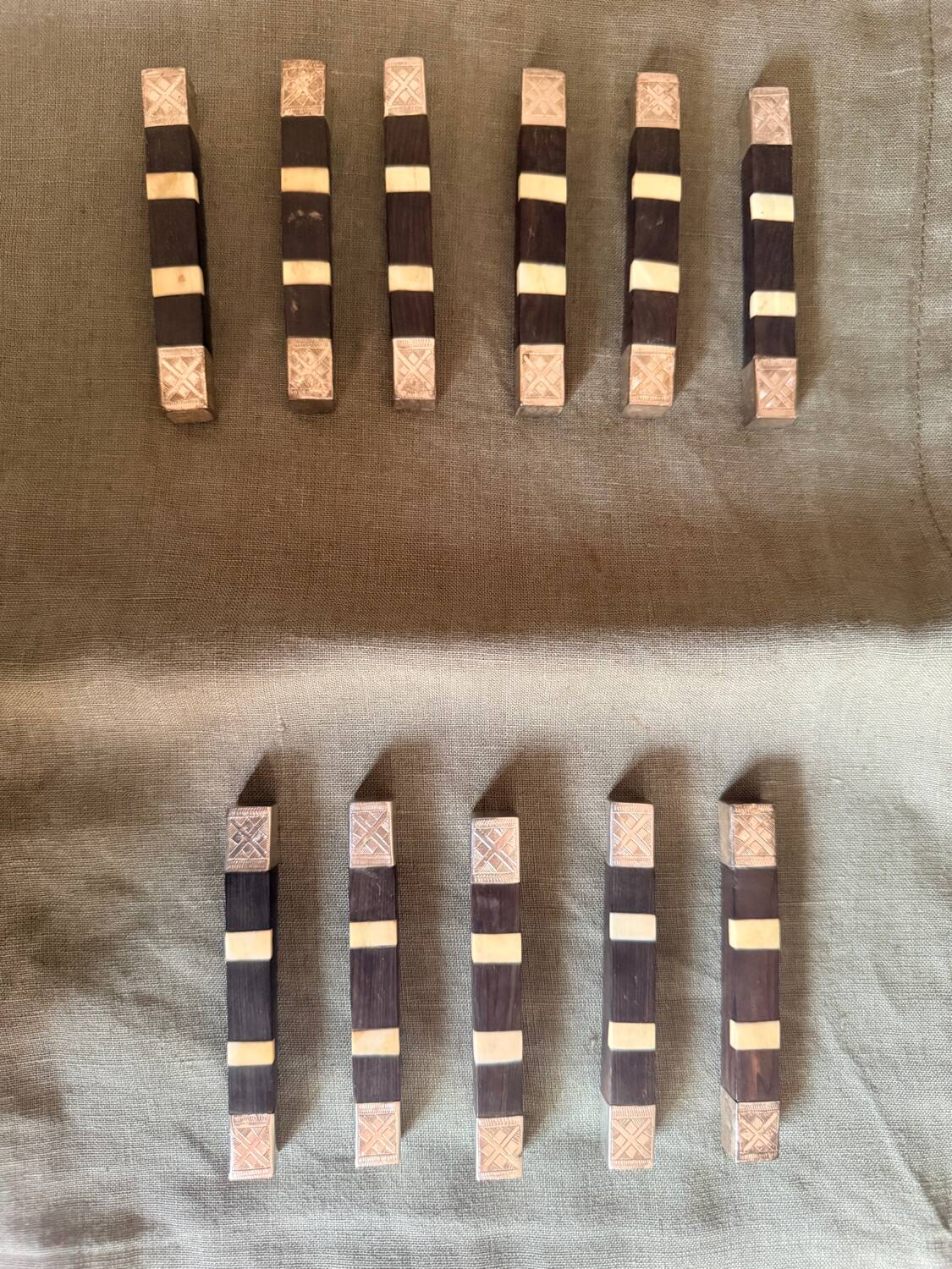 Lot 11 knife rests in ebony and silver-plated metal.