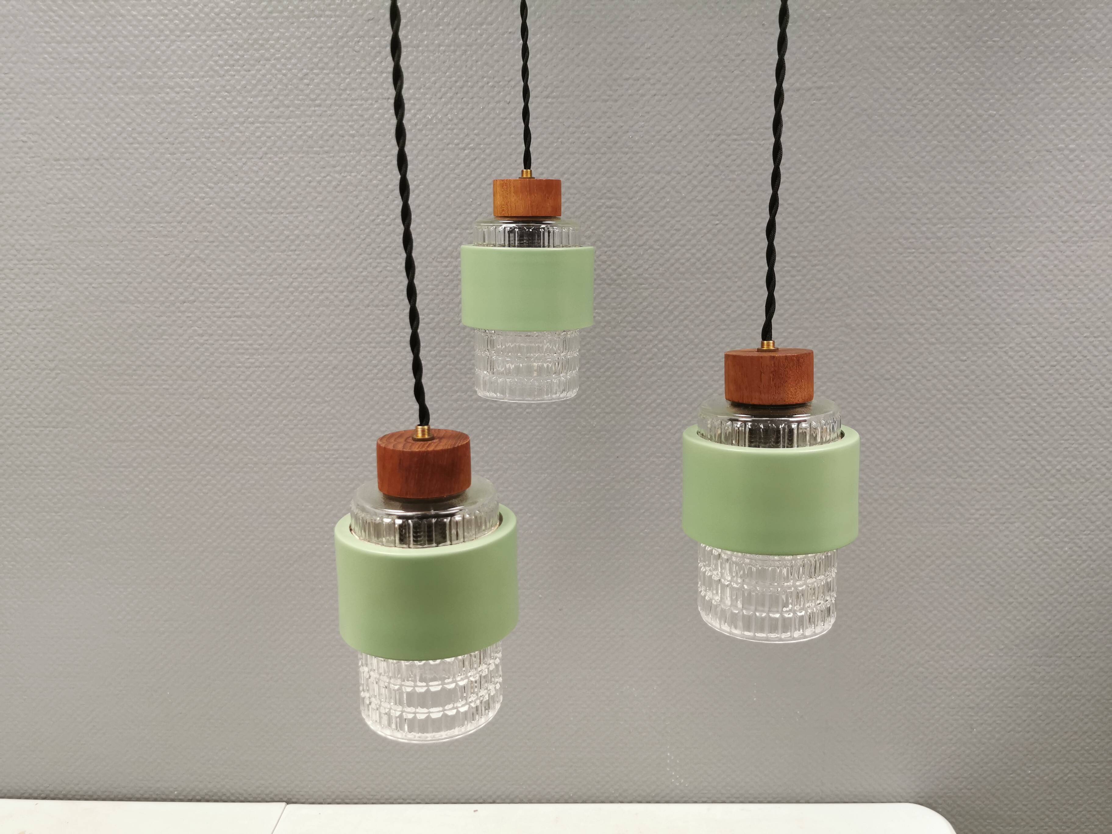 Three-part pendant in crystal glass, teak wood, and thin dusty green metal