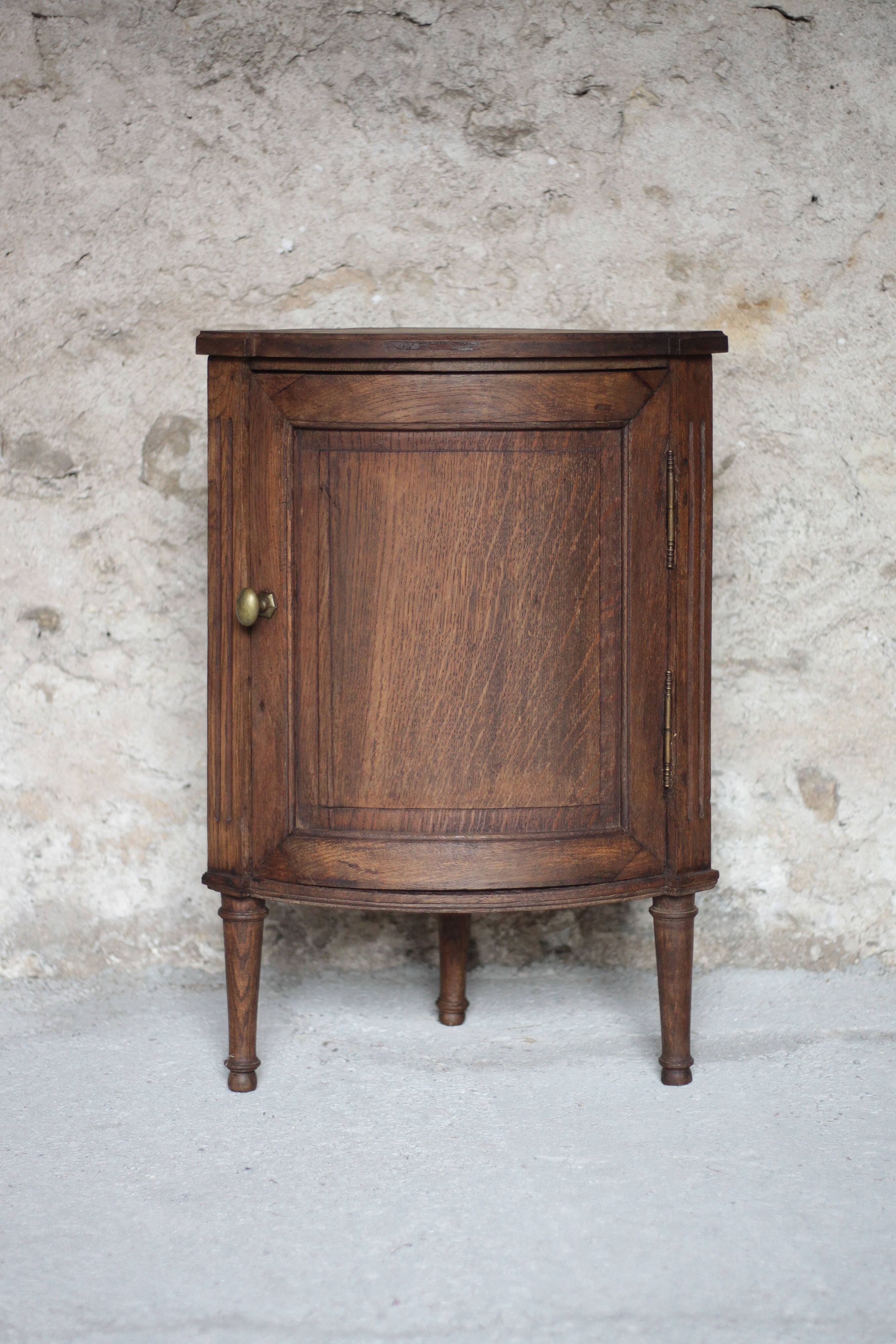 Antique wooden corner cabinet with a curved door.