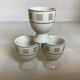 Three egg cups with geometric patterns in beige and brown.