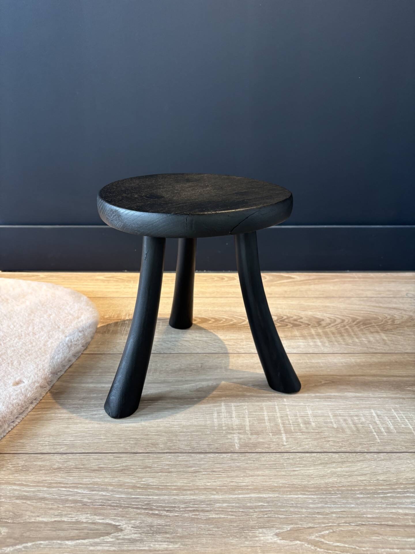 Small black wooden tripod stool