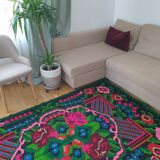 Handwoven colorful Romanian carpet, green and black background with gorgeous colorful flowers