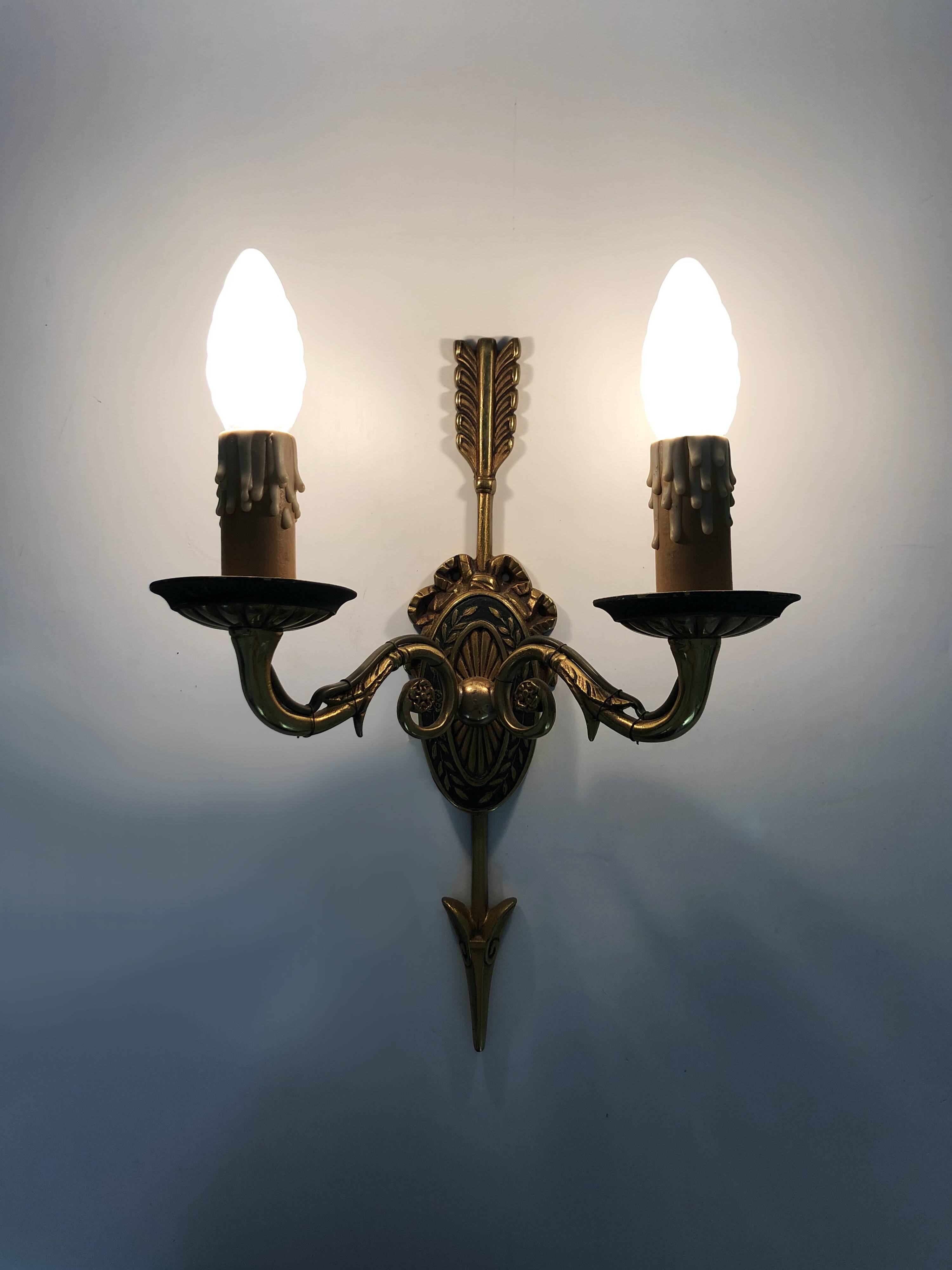 Pair of double-light Empire style arrow wall lights in bronze. Early 20th century
