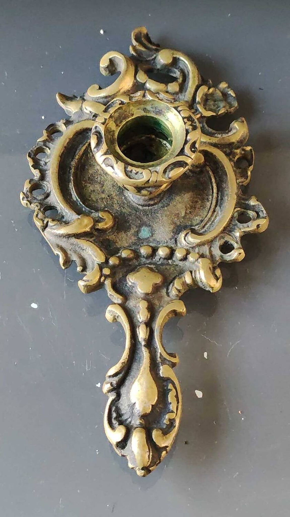 Antique Baroque/Rocaille style hand candle holder. In bronze with an old gold patina.