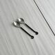 Two small hammered metal teaspoons with a snail pattern.