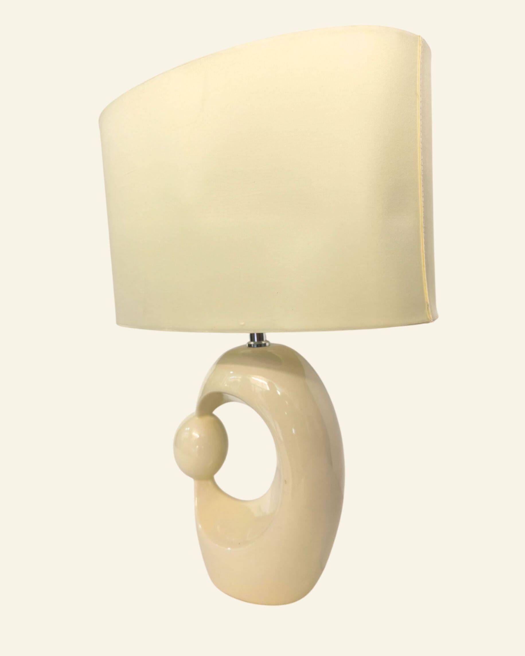 Cream ceramic table lamp with a mid-century design, featuring a lampshade.