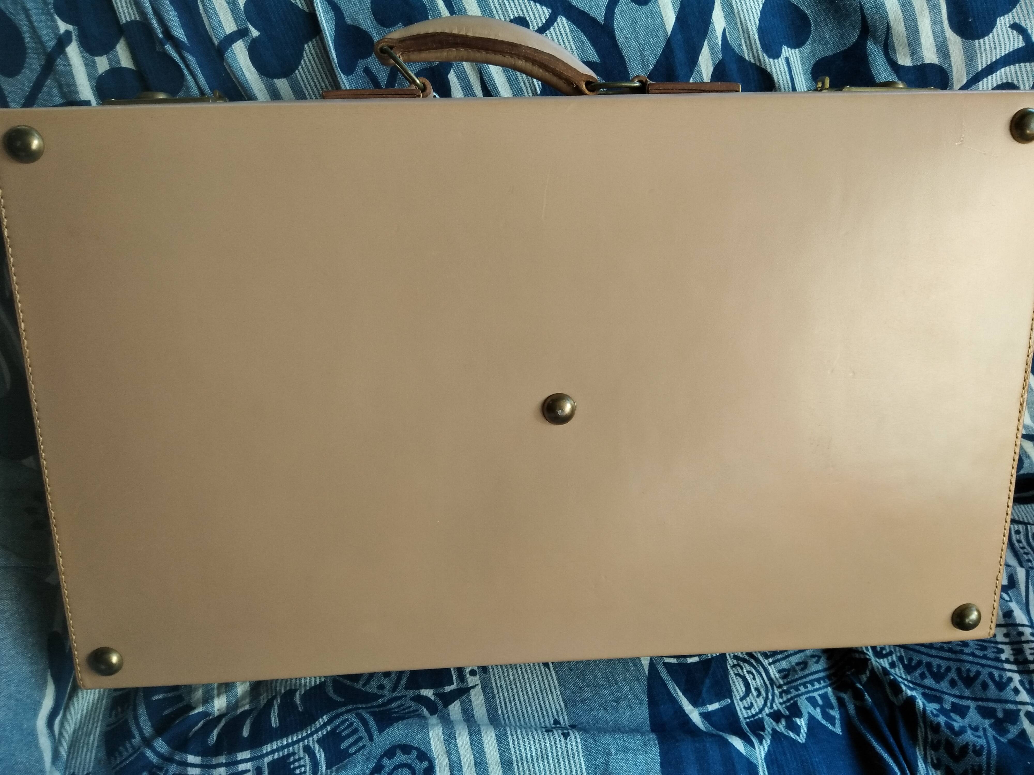 Old leather suitcase with its protective cover