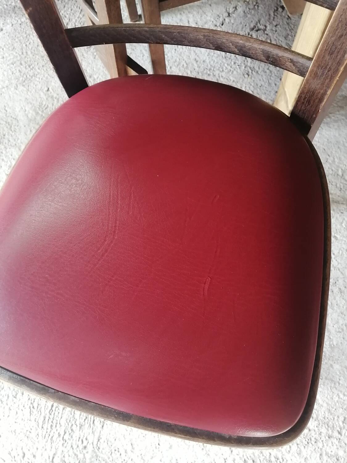 Set of 19 vintage wooden bistro chairs with red faux leather.