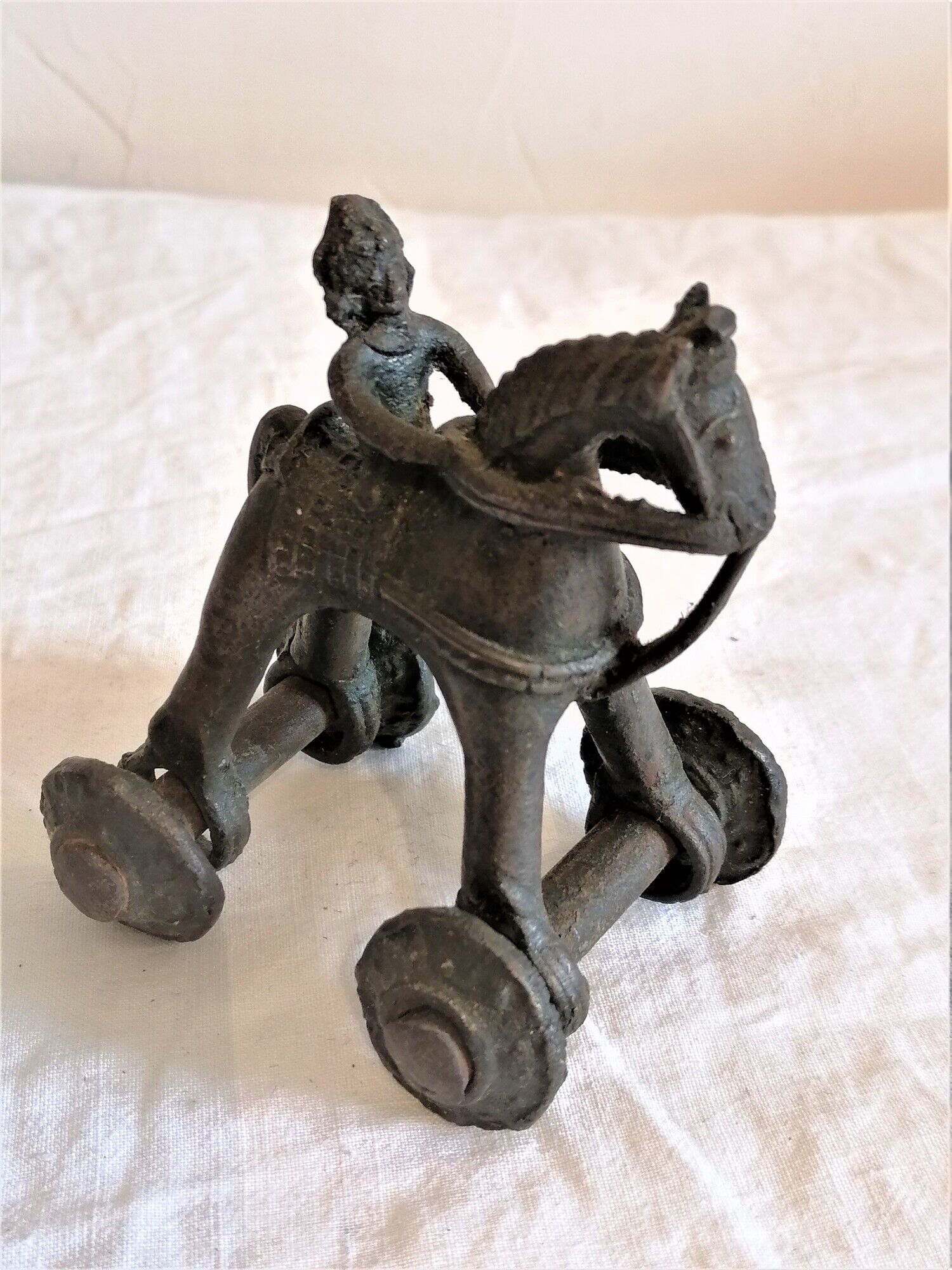 Old child's toy. Horse with bronze wheels. Ethnic object.